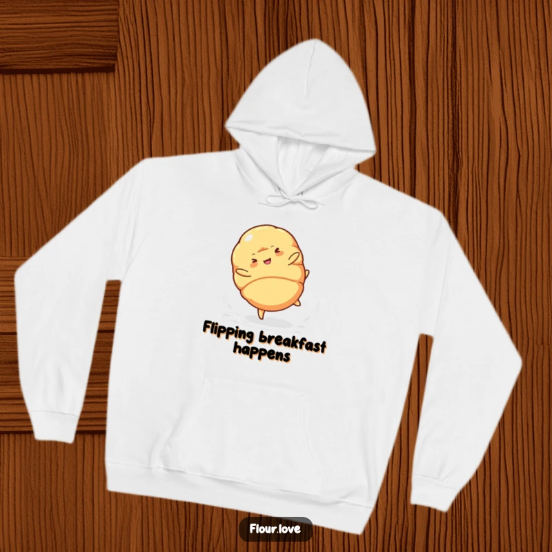 Funny croissant character performing a cartwheel, spilling powdered sugar, a warm and humorous hoodie for cozy days.